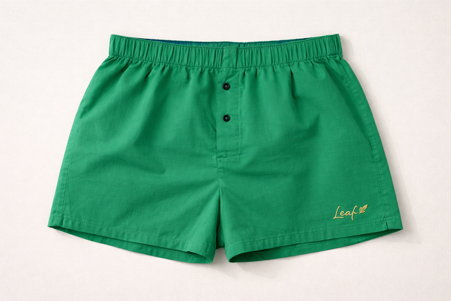 Green shorts with a brand logo on a light gray background